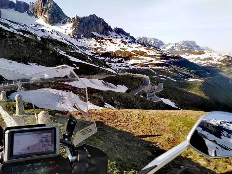 View of the snow capped mountains from a BMW motorcycle.