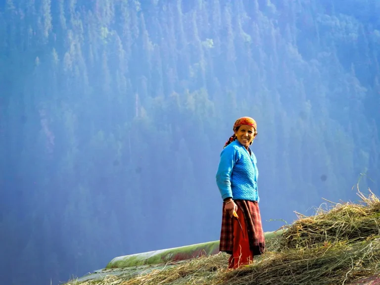 Local woman putting out grass to dry in India.