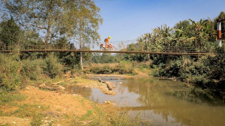 Riding across a wooden bridge in Laos.