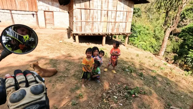 local children in Thailand waiting to say hello as riders pass