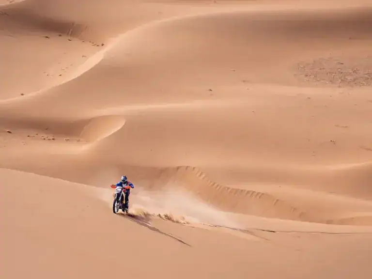 Solo dirt bike rider tackling sand dunes on a Morocco enduro trip